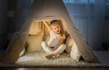 Little girl in teepee tent in room