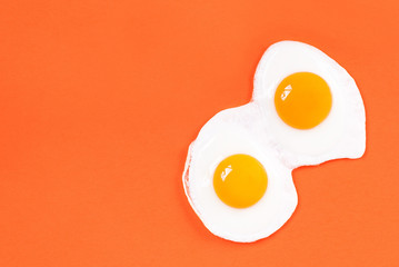 fried eggs fried eggs from two eggs on an orange background