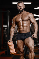 Old brutal strong bodybuilder athletic men pumping up muscles with dumbbells
