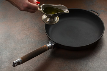 The hand of Chef preparing to pour vegetable oil to the pan
