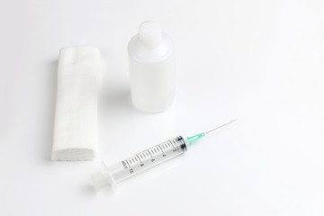 Medical bandage roll, antiseptic and disposable syringe on white background. 