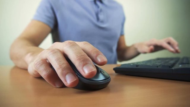 Close up of hands typing on computer keyboard and mouse