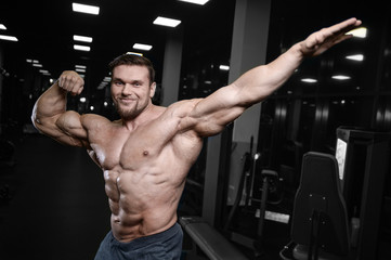 Fototapeta na wymiar Brutal strong bodybuilder athletic men pumping up muscles with dumbbells.