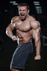 Fototapeta na wymiar Brutal strong bodybuilder athletic men pumping up muscles with dumbbells.