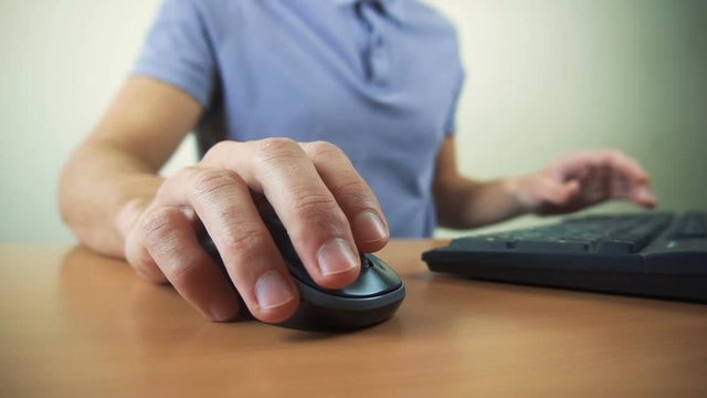 Close up of hands typing on computer keyboard and mouse