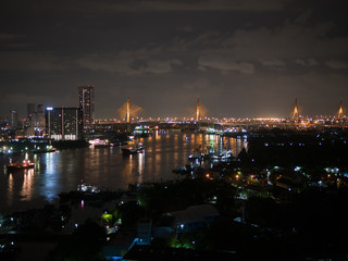 Fototapeta na wymiar River, city and bridge view at night from high condominium