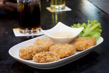 Fried shrimp with sweet sauce on black floor.