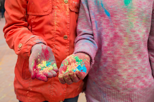 Hands of young people with Indian dyes on Holi color festival