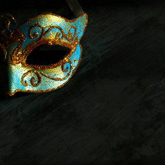 Image of elegant blue and gold venetian, mardi gras mask over black background.