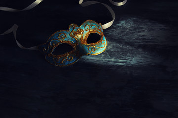 Image of elegant blue and gold venetian, mardi gras mask over black background.