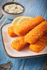 Close-up of fish fingers served with lemon slices