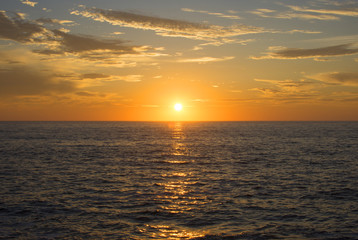 Magnificent setting sun centered over ocean