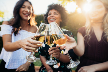 Female friends having drinks at party outdoors - Powered by Adobe