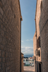 Fototapeta na wymiar Pedestrian access between buildings in the Bol port area, on the island of Brac, Croatia.