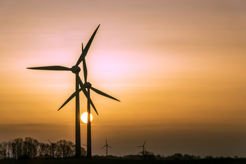 Wind turbines (alternative energy source) as silhouette during sunrise. Concept: Renewable Energies