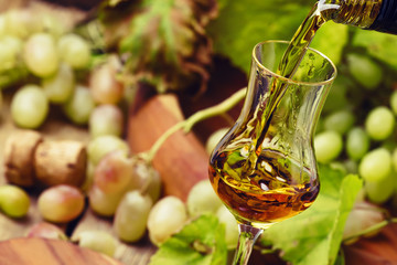 Golden Grappa Being Poured Into Shot Glass, Rustic Still Life, Selective Focus