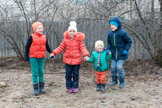 Adorable little children in colorful clothes playing in the winter farmyard. Creative rest with children on a pig farm