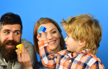 Man with beard, woman and boy play on blue background