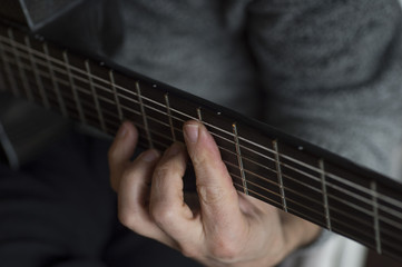 Fototapeta na wymiar Elderly man playing carbon fiber guitar