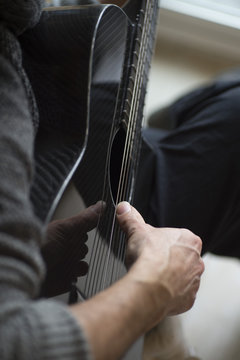 Elderly man playing carbon fiber guitar