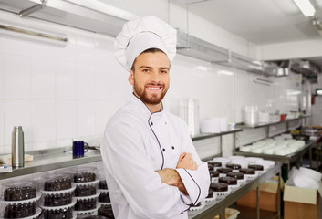 Man confectioner with a cake in his hands in the pastry bakery.