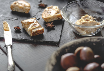 Sweet Chestnut Cream toasts with rosemary honey and anise stars. Rustic wooden background. Selective focus