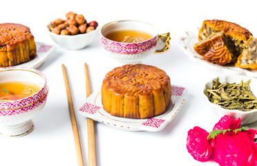Homemade moon cakes with tea,tea leaves, walnut served on white