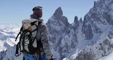 Climber mountaineer man reaching snowy mount top with ice axe in sunny day.Mountaineering ski activity. Skier people winter snow sport in alpine mountain outdoor.Back view.Slow motion 60p 4k video - Powered by Adobe