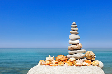 Fototapeta na wymiar White rock Zen against the background of summer sea and blue sky. Concept of balance, harmony and meditation.