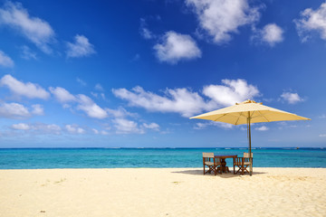 Table, chairs and umbrella on sand beach in Mauritius Island