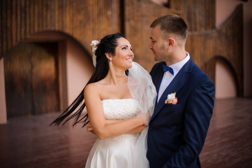 Fototapeta premium Beautiful brunette bride looking at her handsome groom