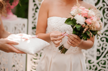 Obraz na płótnie Canvas Bride dressed in a beautiful white wedding dress holding a ring