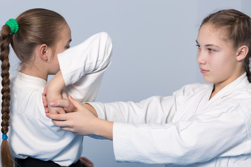 Two girls in black hakama practice Aikido