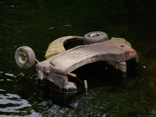 abandoned childrens toy buggy in a drained canal