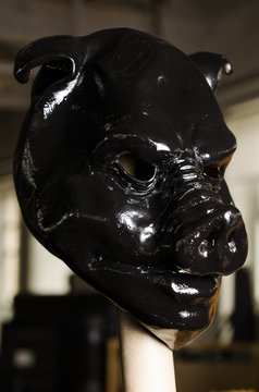 slick oily black pig mask painted in shiny latex black