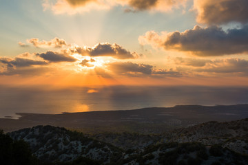Obraz premium Sunrays of evening sun behind clouds at Cyprus coast HDR landscape.