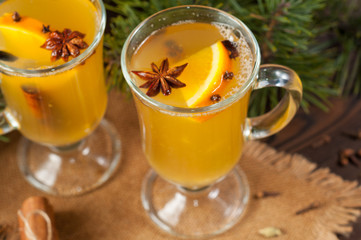 White mulled wine with various spices on a wooden background. Hot alcoholic beverage