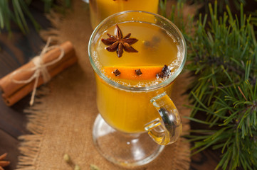 White mulled wine with various spices on a wooden background. Hot alcoholic beverage