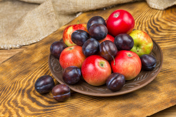 Fototapeta na wymiar fruits, apples and plums on a plate