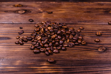 Pile of the roasted coffee beans on wooden table