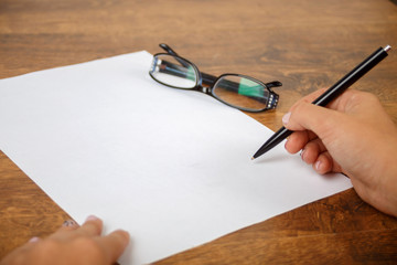Hand filling in the form on a4 format vertical sheet