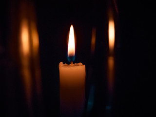 on a black background bright yellow candles, a holiday or a church burn