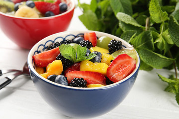 Bowl with delicious fruit salad on wooden table