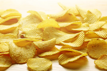 A lot of crisps potato on a wood background