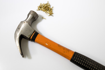 Hammer and gold tacks in a white background