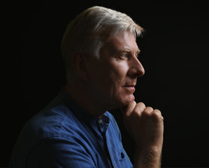 Portrait of thoughtful mature man on dark background