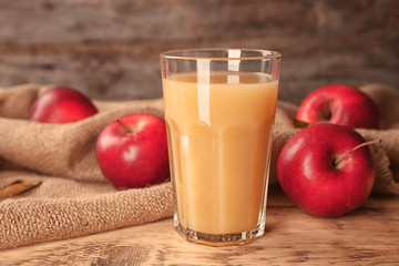 Glass of delicious apple juice on table