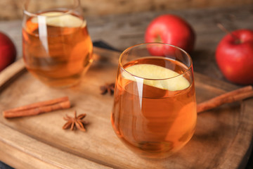 Glasses of delicious apple juice on wooden board