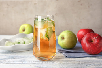 Apple juice with ice cubes and mint on table