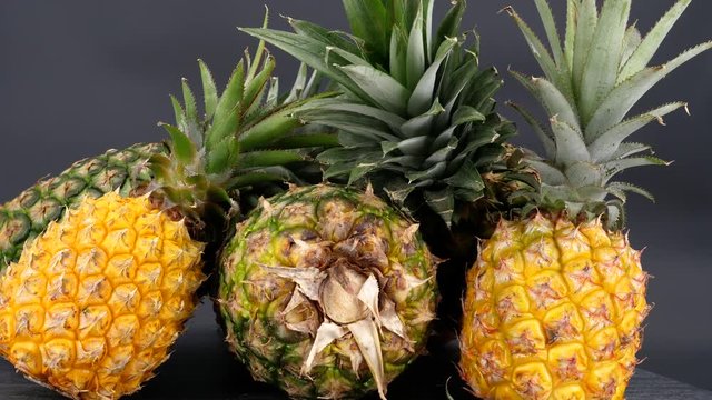 Rotating pineapple fruits isolated on a black background (loopable)